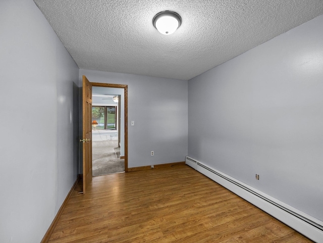 5252 5th St NE, Columbia Heights, MN 55421 - unfurnished room with baseboard heating, a textured ceiling, and wood finished floors