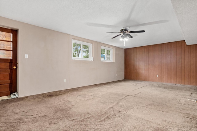 1700 Laramie Trl, Brooklyn Park, MN 55444 - empty room featuring ceiling fan, wood walls, carpet floors, and a textured ceiling