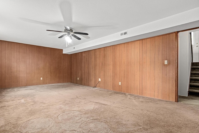 1700 Laramie Trl, Brooklyn Park, MN 55444 - carpeted spare room featuring stairs, wooden walls, and a ceiling fan