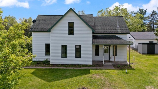 8965 Market St, Sturgeon Lake, MN 55783 - rear view of house with a porch, a lawn, and a shingled roof