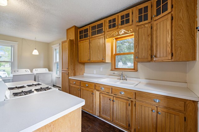 8965 Market St, Sturgeon Lake, MN 55783 - kitchen featuring a sink, a textured ceiling, brown cabinetry, glass insert cabinets, and light countertops