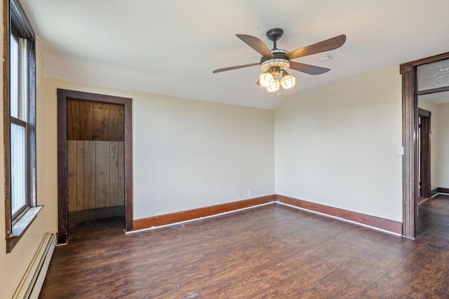 8965 Market St, Sturgeon Lake, MN 55783 - spare room with a baseboard heating unit, wood finished floors, baseboards, a ceiling fan, and a textured ceiling