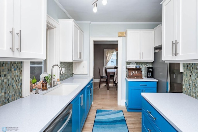 1328 6th St S, Fargo, ND 58103 - kitchen with blue cabinets, a sink, white cabinetry, light countertops, and crown molding