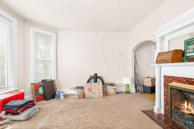 220 12th Ave E, Duluth, MN 55805 - carpeted living room featuring ornamental molding, arched walkways, and a fireplace with flush hearth