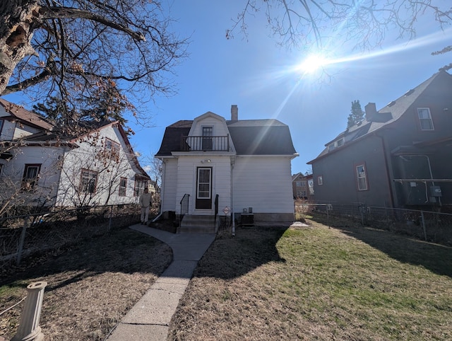 1713 Penn Ave N, Minneapolis, MN 55411 - rear view of house featuring entry steps, a gambrel roof, a chimney, a balcony, and central AC