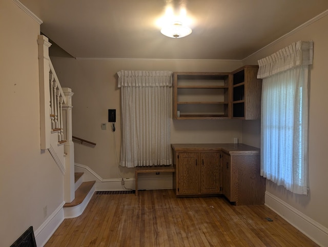 1713 Penn Ave N, Minneapolis, MN 55411 - unfurnished dining area featuring stairs, baseboards, wood-type flooring, and crown molding