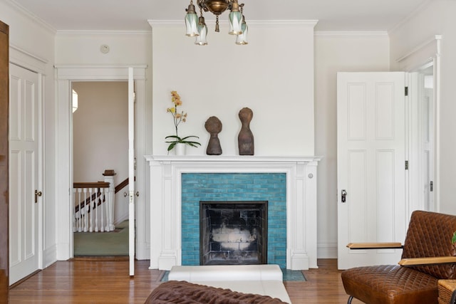 226 Grotto St S, Saint Paul, MN 55105 - living area with wood finished floors, crown molding, a tiled fireplace, and a chandelier