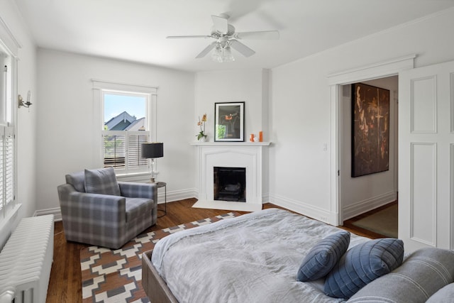 226 Grotto St S, Saint Paul, MN 55105 - bedroom with radiator heating unit, a fireplace with flush hearth, wood finished floors, and ceiling fan