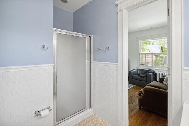 226 Grotto St S, Saint Paul, MN 55105 - ensuite bathroom with a shower stall, a wainscoted wall, wood finished floors, tile walls, and radiator