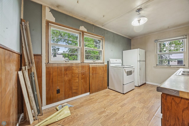 1550 13 1/2 St S, Fargo, ND 58103 - kitchen with white appliances, plenty of natural light, light wood-style flooring, wood walls, and brown cabinetry