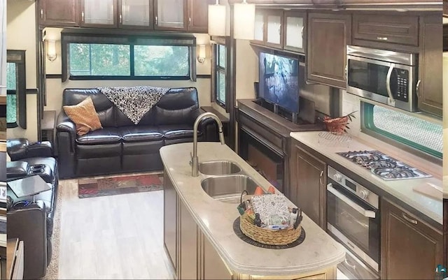 1437 Severson Rd, Summit Twp, WI 54836 - kitchen with stainless steel appliances, a sink, an island with sink, dark brown cabinets, and light countertops