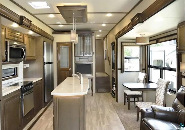 1437 Severson Rd, Summit Twp, WI 54836 - kitchen with appliances with stainless steel finishes, light countertops, an island with sink, light wood-type flooring, and a sink