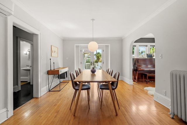 4705 Lyndale Ave S, Minneapolis, MN 55419 - dining room with radiator heating unit, a wall mounted AC, healthy amount of natural light, crown molding, and light wood-type flooring