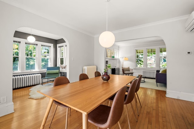 4705 Lyndale Ave S, Minneapolis, MN 55419 - dining room featuring radiator, arched walkways, hardwood / wood-style floors, and crown molding