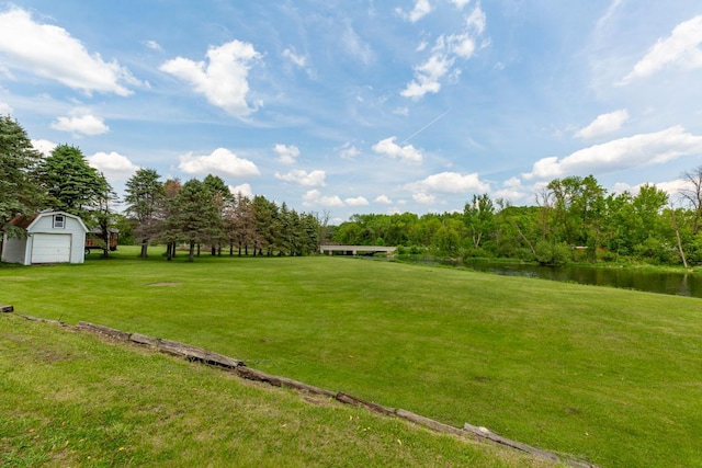425 Franklin St, Morristown, MN 55052 - view of grassy yard with a water view, an outdoor structure, and a detached garage