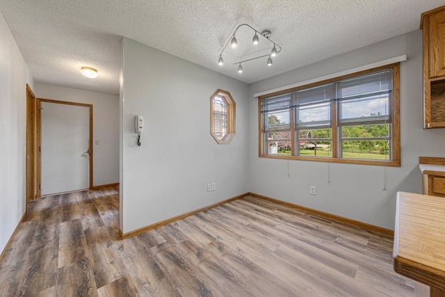 425 Franklin St, Morristown, MN 55052 - unfurnished dining area featuring wood finished floors, a textured ceiling, and baseboards