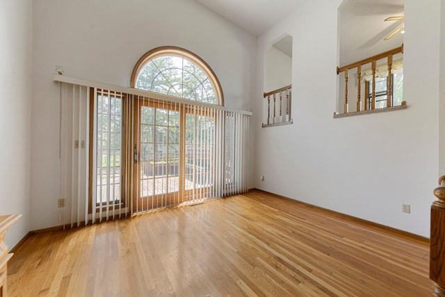425 Franklin St, Morristown, MN 55052 - unfurnished room featuring wood finished floors, ceiling fan, baseboards, and high vaulted ceiling