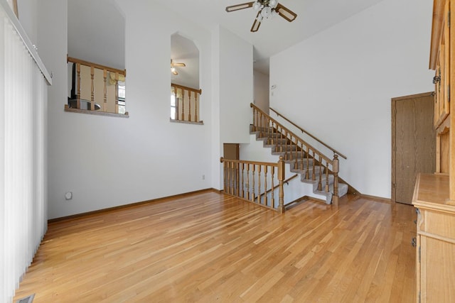 425 Franklin St, Morristown, MN 55052 - unfurnished room with ceiling fan, stairs, light wood-style floors, arched walkways, and baseboards