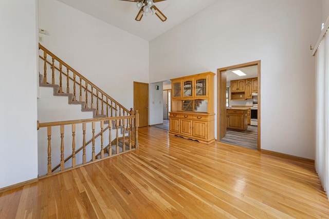 425 Franklin St, Morristown, MN 55052 - empty room with a towering ceiling, a ceiling fan, light wood-style floors, stairs, and baseboards
