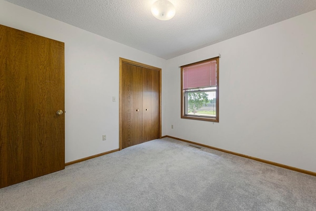 425 Franklin St, Morristown, MN 55052 - unfurnished bedroom with carpet floors, a closet, baseboards, and a textured ceiling