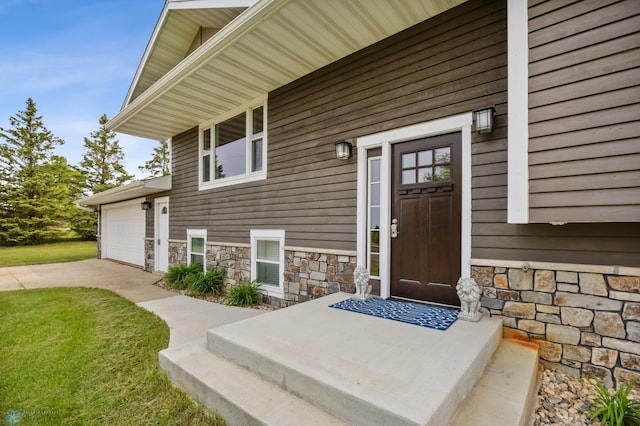 18117 Cherry Creek Ln, Erie Twp, MN 56501 - view of exterior entry with stone siding, driveway, a lawn, and an attached garage