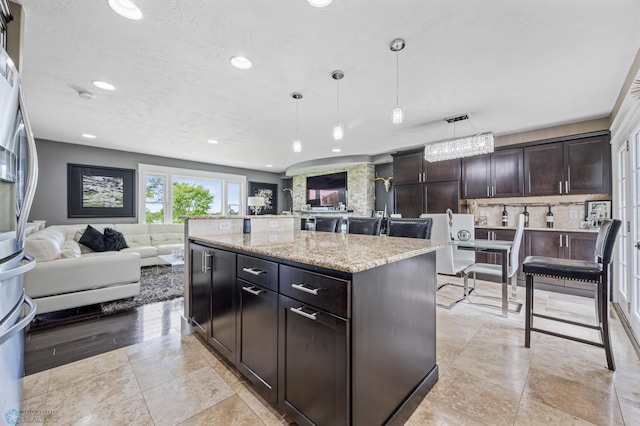 18117 Cherry Creek Ln, Erie Twp, MN 56501 - kitchen with open floor plan, recessed lighting, light stone countertops, decorative light fixtures, and dark brown cabinets