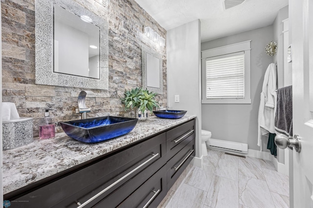 18117 Cherry Creek Ln, Erie Twp, MN 56501 - bathroom with decorative backsplash, double vanity, a baseboard heating unit, toilet, and baseboards