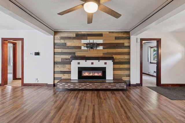 1148 Geranium Ave E, Saint Paul, MN 55106 - unfurnished living room with wood finished floors, wood walls, baseboards, a glass covered fireplace, and a ceiling fan