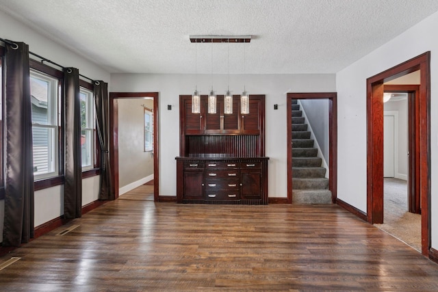 1148 Geranium Ave E, Saint Paul, MN 55106 - unfurnished living room with dark wood-type flooring, a textured ceiling, baseboards, and stairway