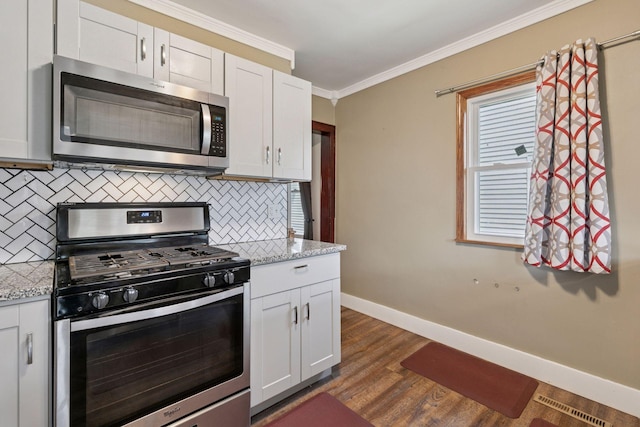 1148 Geranium Ave E, Saint Paul, MN 55106 - kitchen featuring appliances with stainless steel finishes, baseboards, decorative backsplash, crown molding, and dark wood-style flooring