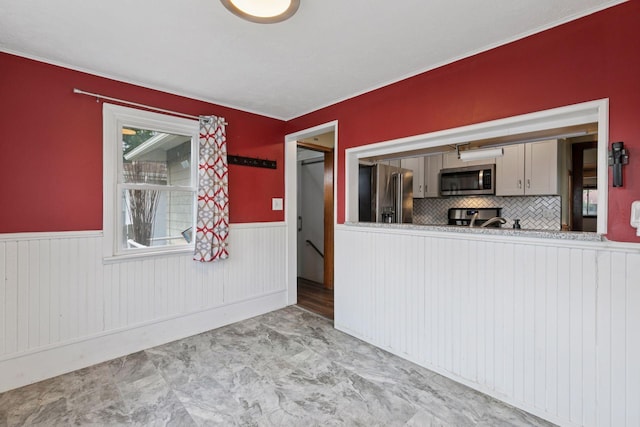 1148 Geranium Ave E, Saint Paul, MN 55106 - kitchen with appliances with stainless steel finishes, wainscoting, and backsplash