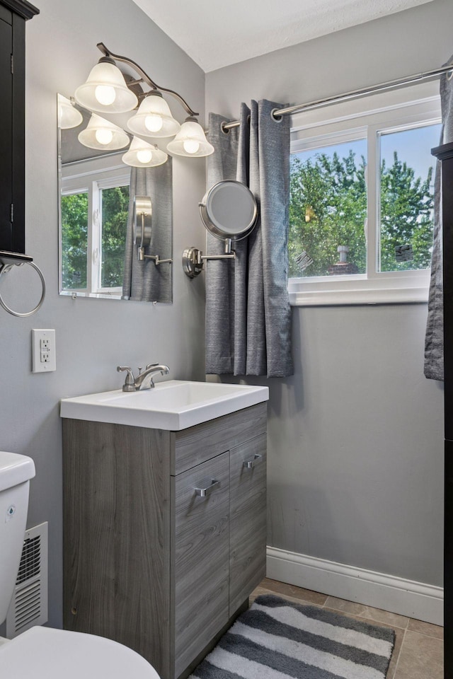 1148 Geranium Ave E, Saint Paul, MN 55106 - half bathroom with toilet, vanity, baseboards, and tile patterned floors