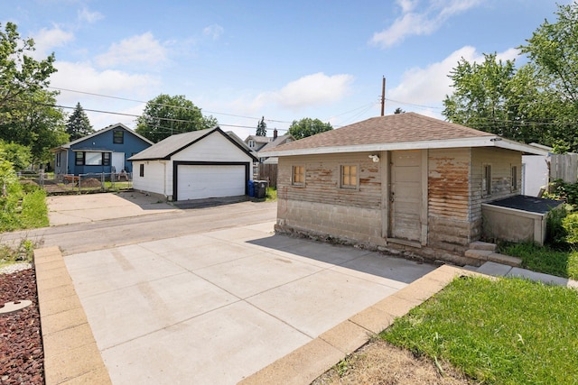 1148 Geranium Ave E, Saint Paul, MN 55106 - view of front of home featuring an outbuilding, a detached garage, and a shingled roof