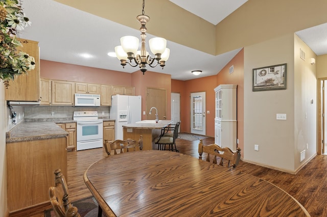 11645 Alpine Dr, Monticello, MN 55362 - dining space featuring a chandelier, dark wood-style floors, and baseboards
