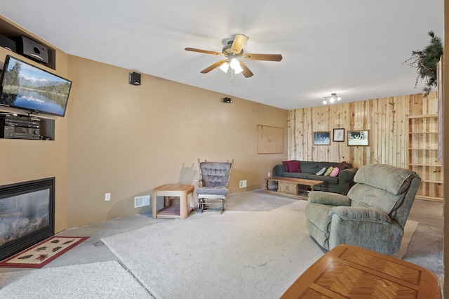 11645 Alpine Dr, Monticello, MN 55362 - living area with wooden walls, a ceiling fan, and a fireplace with flush hearth