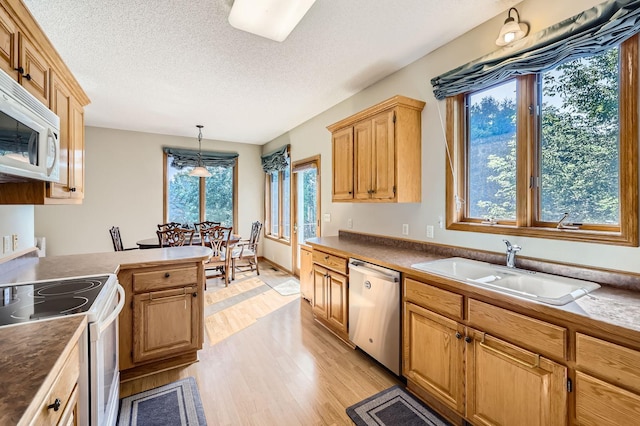 1110 Lia Ct, Northfield, MN 55057 - kitchen featuring white appliances, light wood-style floors, pendant lighting, a textured ceiling, and a peninsula