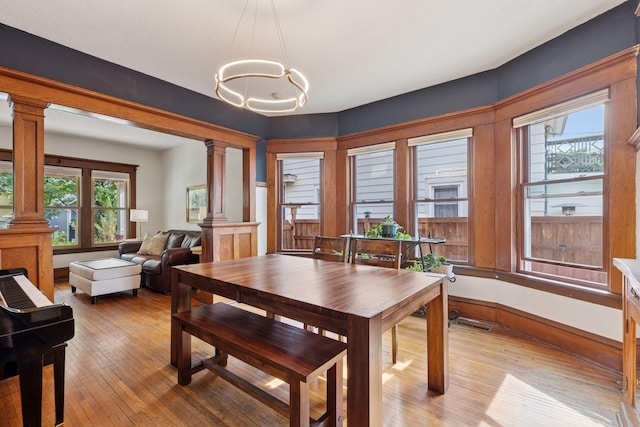 896 Carroll Ave, Saint Paul, MN 55104 - dining area featuring ornate columns, light wood-style flooring, and a chandelier