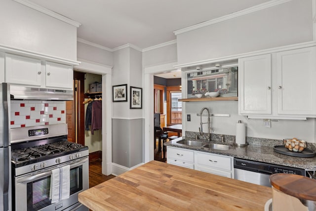896 Carroll Ave, Saint Paul, MN 55104 - kitchen featuring under cabinet range hood, stainless steel appliances, butcher block countertops, white cabinetry, and crown molding