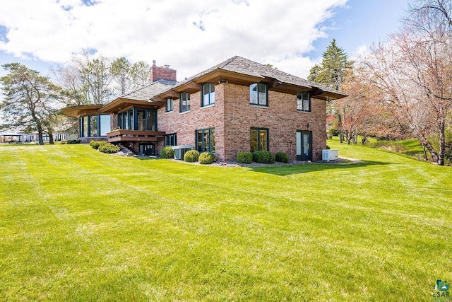 2900 London Rd, Duluth, MN 55804 - back of house with a chimney, central AC, brick siding, and a lawn