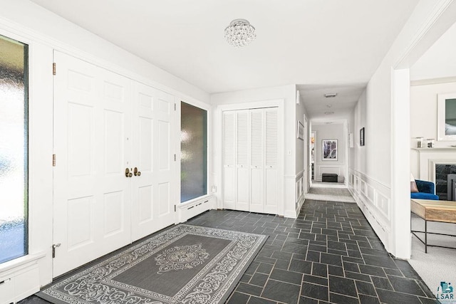 2900 London Rd, Duluth, MN 55804 - entrance foyer with dark stone finish flooring, a wainscoted wall, and a decorative wall