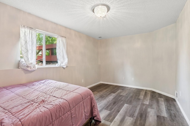 2035 123rd Ave NW, Coon Rapids, MN 55448 - bedroom with wood finished floors, a textured ceiling, and baseboards
