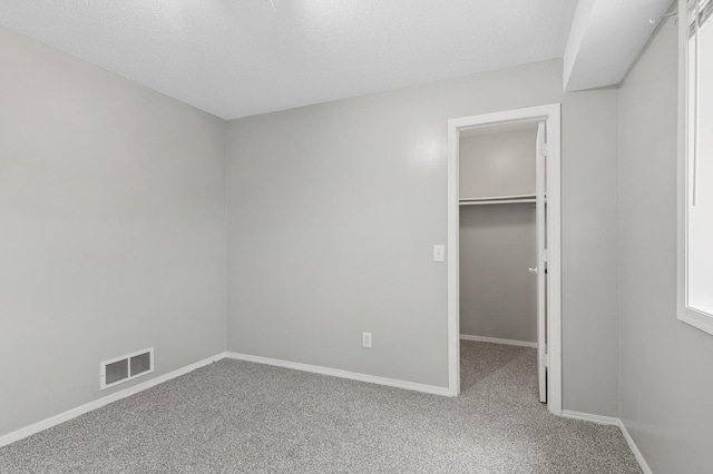 2035 123rd Ave NW, Coon Rapids, MN 55448 - unfurnished bedroom featuring a spacious closet, carpet flooring, and baseboards