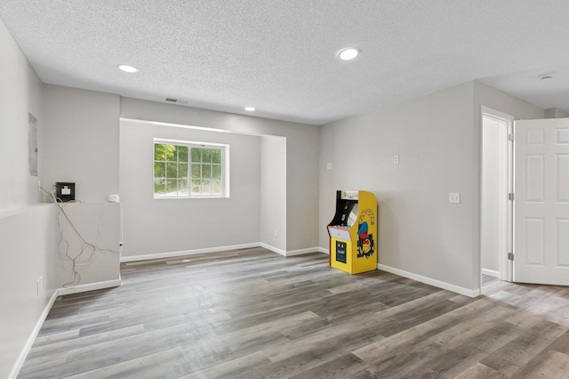 2035 123rd Ave NW, Coon Rapids, MN 55448 - unfurnished room with recessed lighting, wood finished floors, a textured ceiling, and baseboards