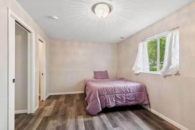 2035 123rd Ave NW, Coon Rapids, MN 55448 - bedroom featuring wood finished floors, a textured ceiling, and baseboards