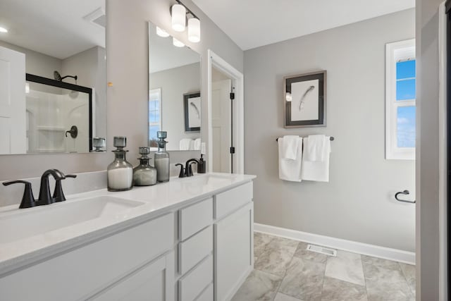 252 6th St NW, Delano, MN 55328 - bathroom featuring double vanity, a shower with shower door, marble finish floors, and baseboards