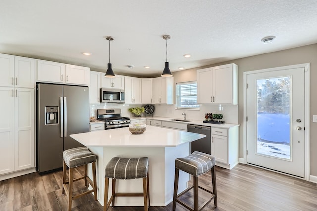 21749 Lilac Dr, Farmington, MN 55024 - kitchen with stainless steel appliances, a kitchen breakfast bar, wood finished floors, and recessed lighting