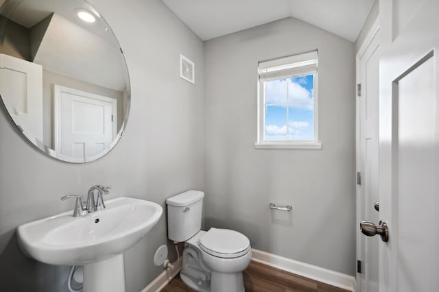 21749 Lilac Dr, Farmington, MN 55024 - half bath featuring wood finished floors, toilet, baseboards, lofted ceiling, and a sink