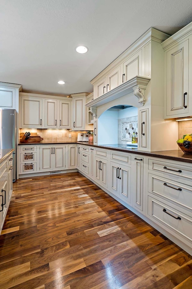 21570 France Blvd, Credit River Twp, MN 55044 - kitchen with dark countertops, freestanding refrigerator, decorative backsplash, dark wood finished floors, and recessed lighting