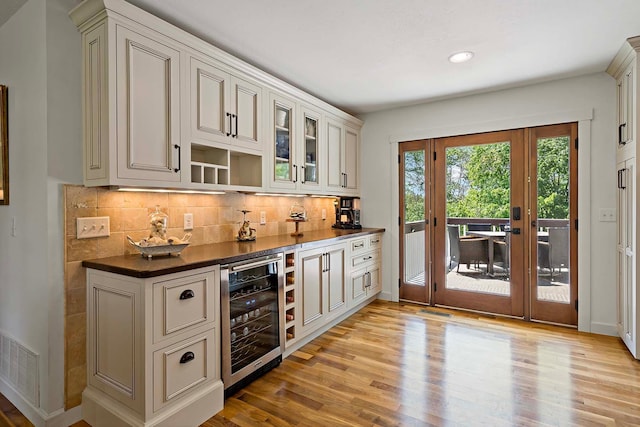 21570 France Blvd, Credit River Twp, MN 55044 - indoor dry bar featuring wine cooler, tasteful backsplash, light wood-style floors, recessed lighting, and baseboards