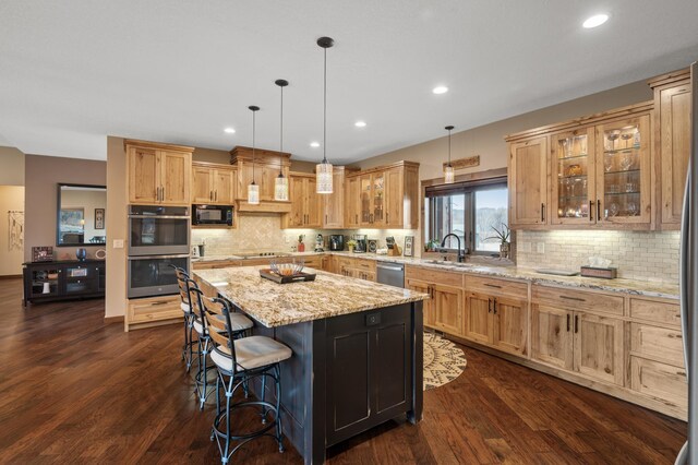 8530 Fir St, Greenfield, MN 55373 - kitchen featuring black appliances, a sink, a center island, a breakfast bar, and dark wood-style floors
